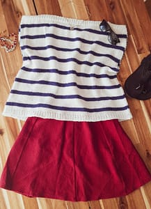 The knitted Harbor Top laid flat with a red skirt and sandals