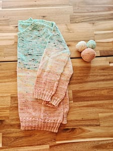 A knit with hand-dyed wool folded in half laying on a table
