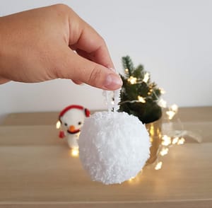 Hand is holding a knit snowball