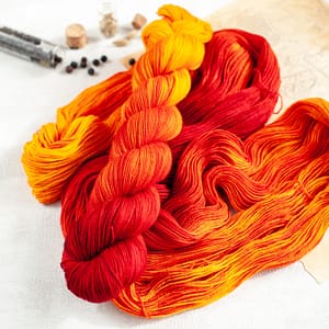 a skein of fingering weight red, orange, and yellow yarn