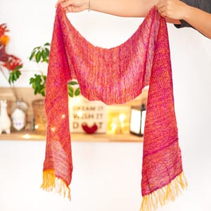 A woven mohair scarf being held by two hands.