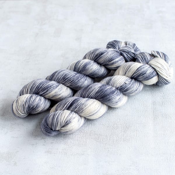 two skeins of DK weight light grey and white yarn