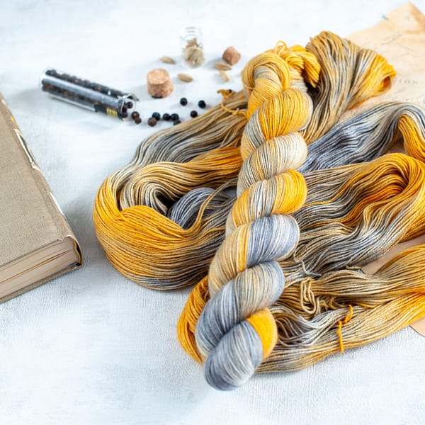 a skein of grey and yellow yarn laying on top of some more yarn