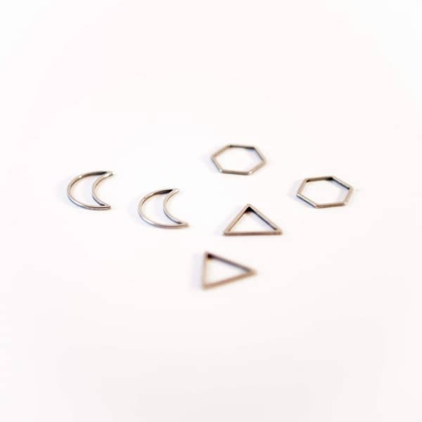 two moon-, two honeycomb- and two triangle-shaped platinum stitch markers