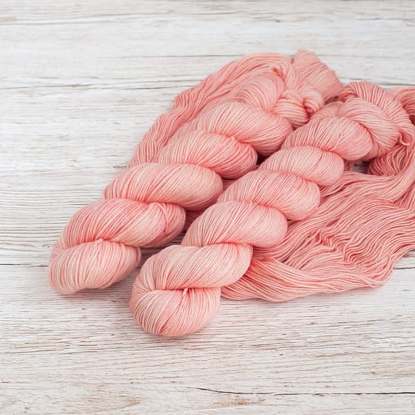 Two pastel pink skeins of yarn