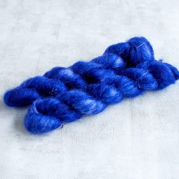 two skeins of lace weight midnight blue mohair yarn