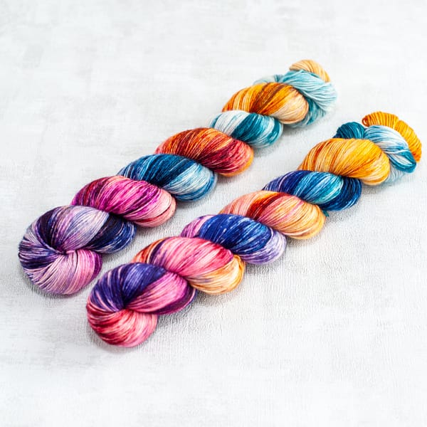 two skeins of fingering weight multi-colored yarn
