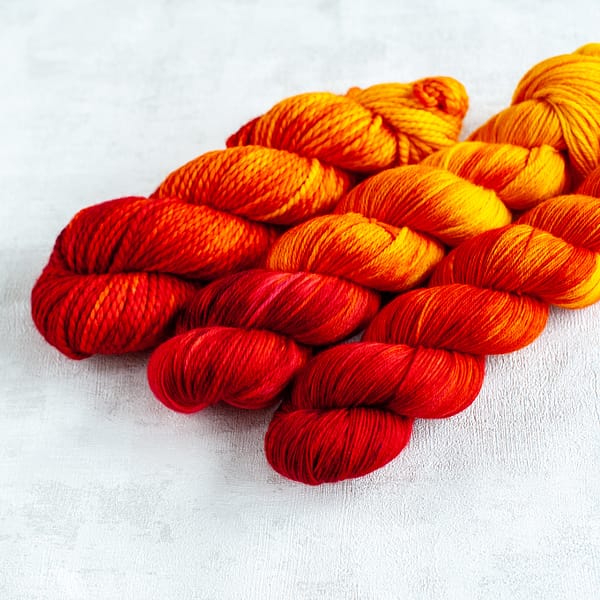 three skeins of red, orange, and yellow yarn