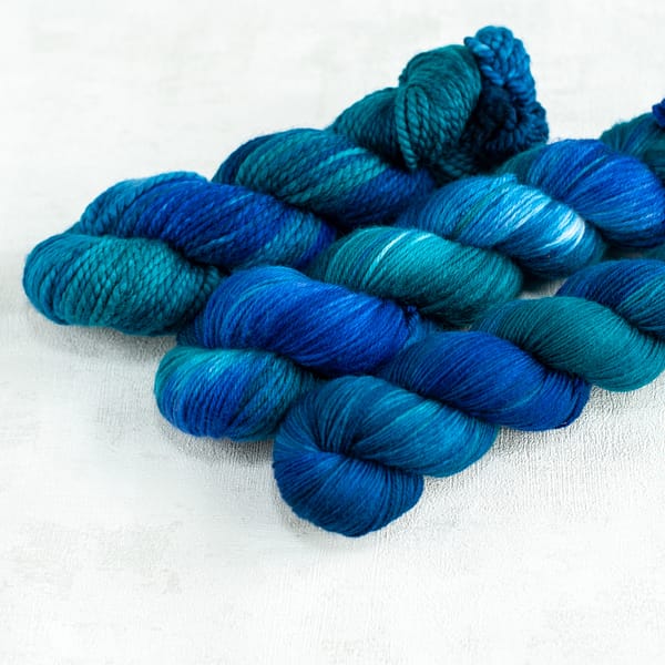 three skeins of blue and green yarn