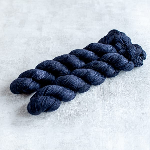 two skeins of fingering weight blue-black yarn