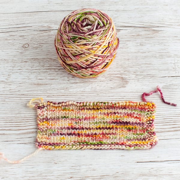 A cake and swatch of multicolored yarn 
