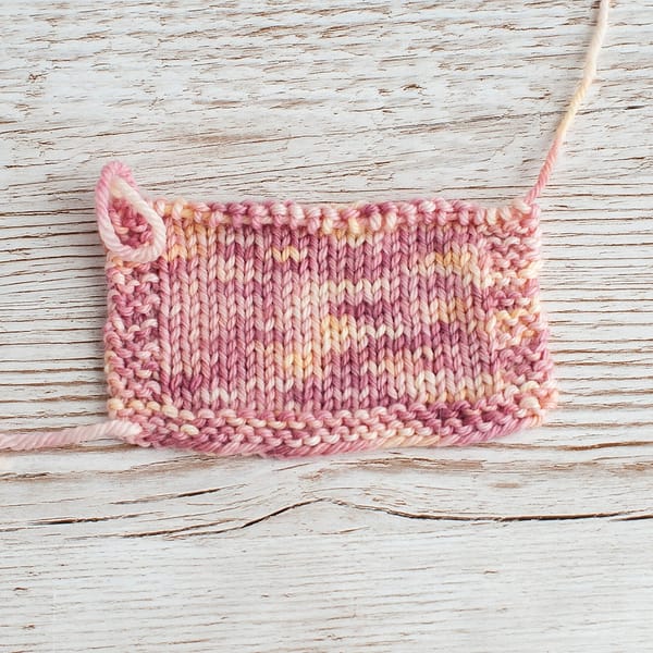 A swatch of pink and cream yarn