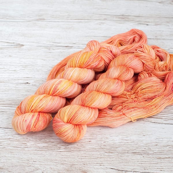 Two skeins of yarn in the color Peach Sorbet