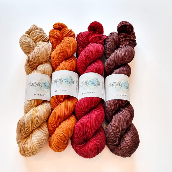 Four skeins of hand dyed merino yarn in fall colors. They are a kit for the Geogradient MKAL