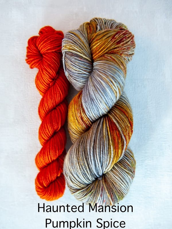 A sock set with the main skein in grey with red and brown speckles and a mini skein in orange