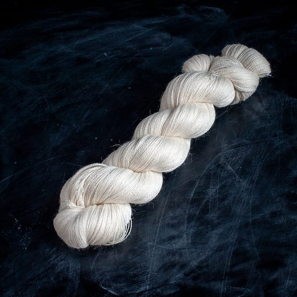 An undyed skein of Suri Merino Silk Lace yarn.
