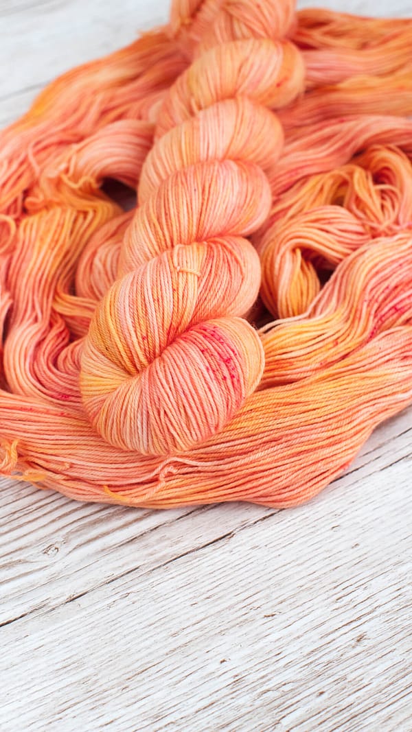 A skein of yarn in the color Peach Sorbet