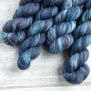four skeins of yarn in the colorway 'Dark Storm'