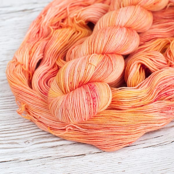 A skein of yarn in the color Peach Sorbet