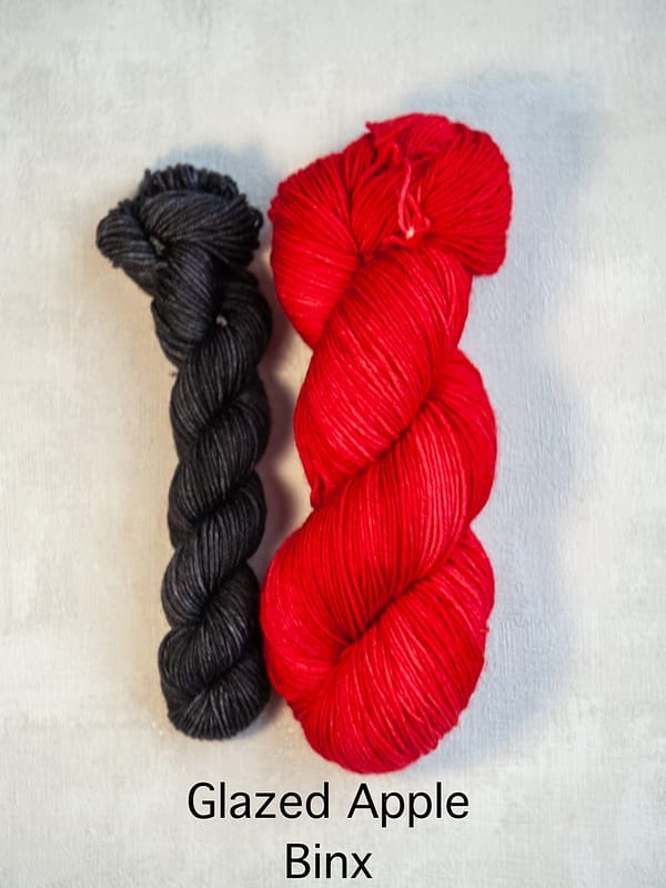 A sock set with the main skein in red and a mini skein in black