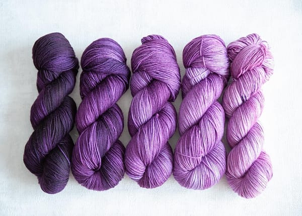 Five skeins in varying shades of purple