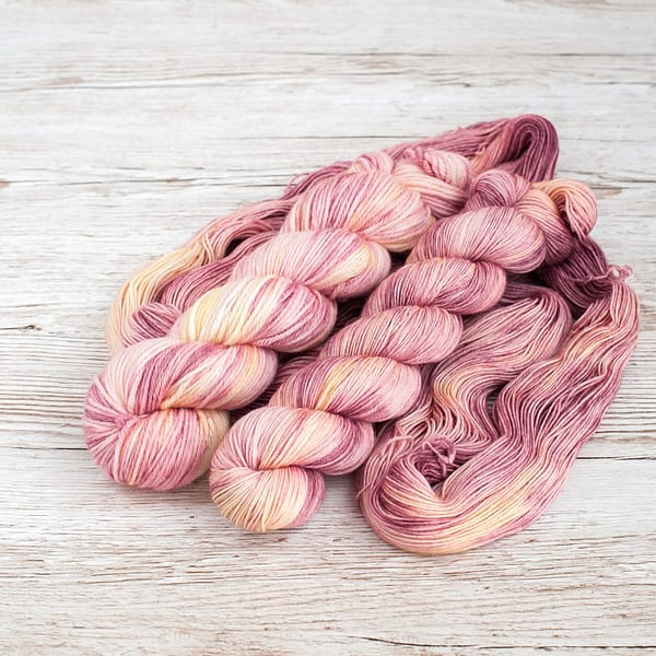 Two skeins of pink and cream yarn 