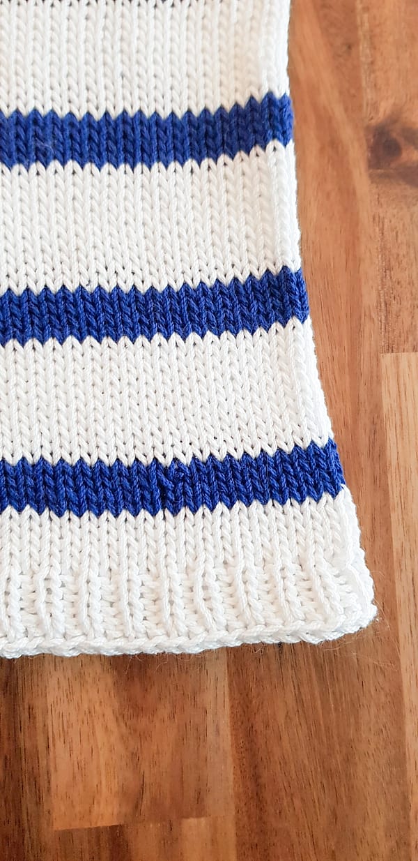 Close-up of the bottom right edge of the Harbor Top, showing two stripes and the ribbing