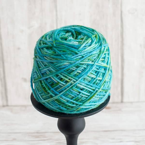 A skein of yarn in the color Pond wound into a cake