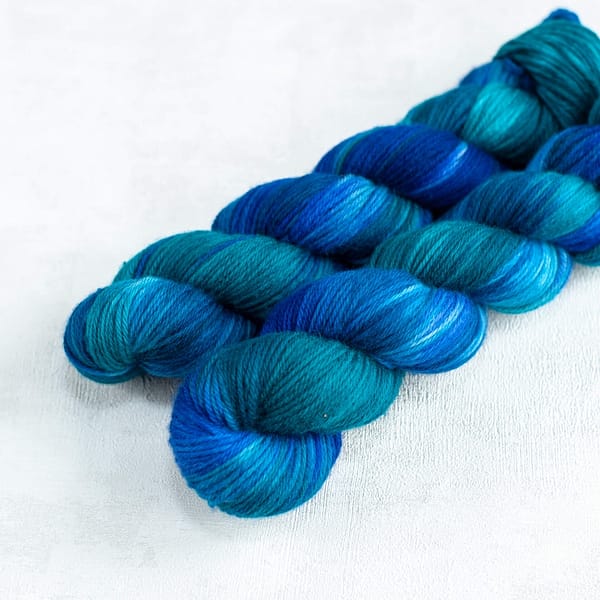 two DK weight skeins of blue and green yarn