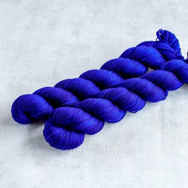 two skeins of fingering weight midnight blue yarn