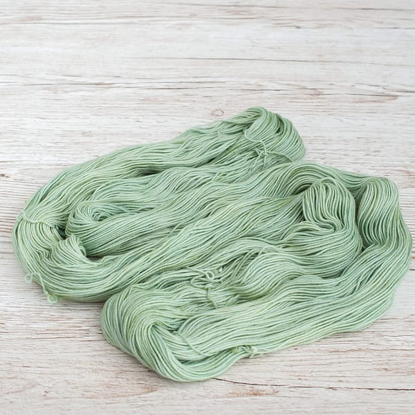 A skein of pale green yarn unwound and laid flat